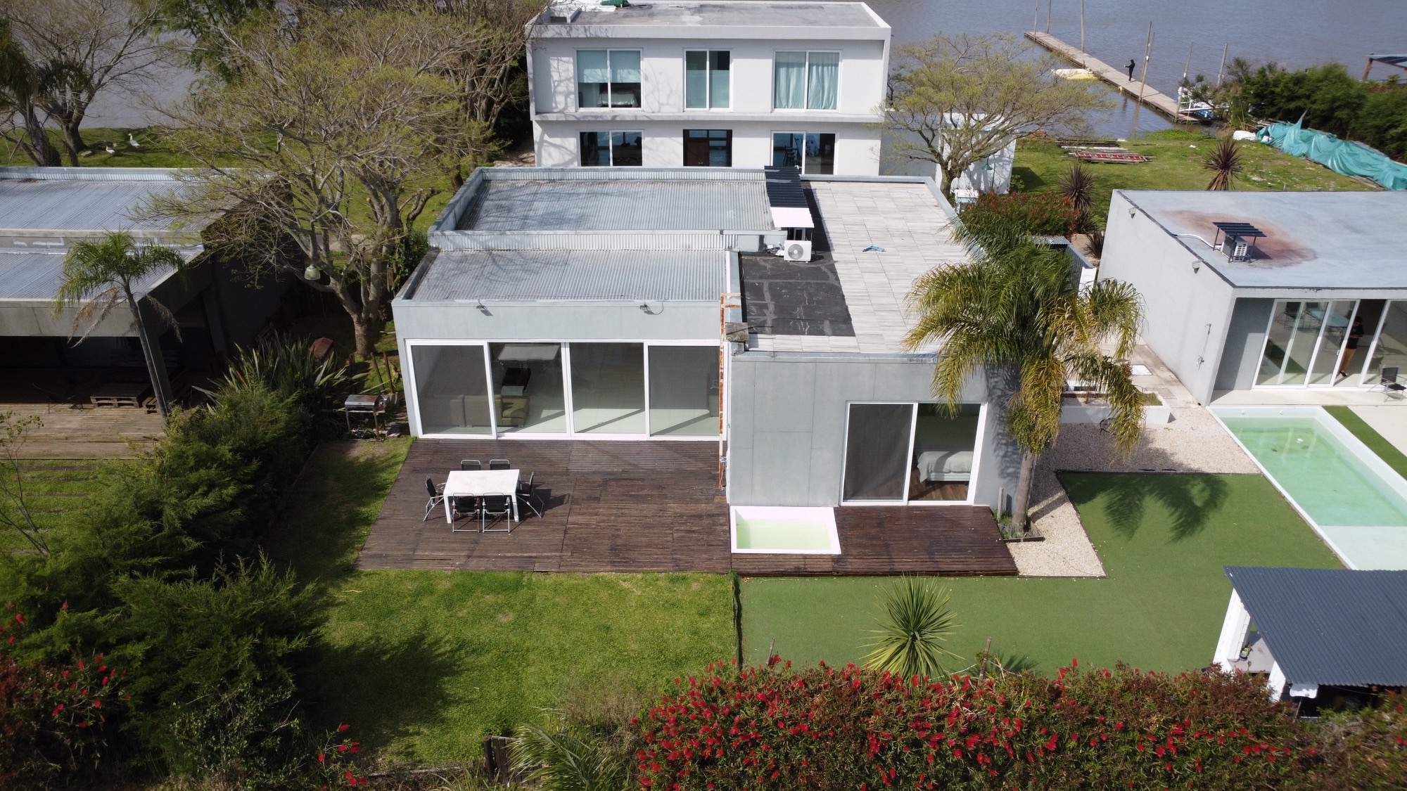 Casa con deck de madera, parque y pileta, vista aérea